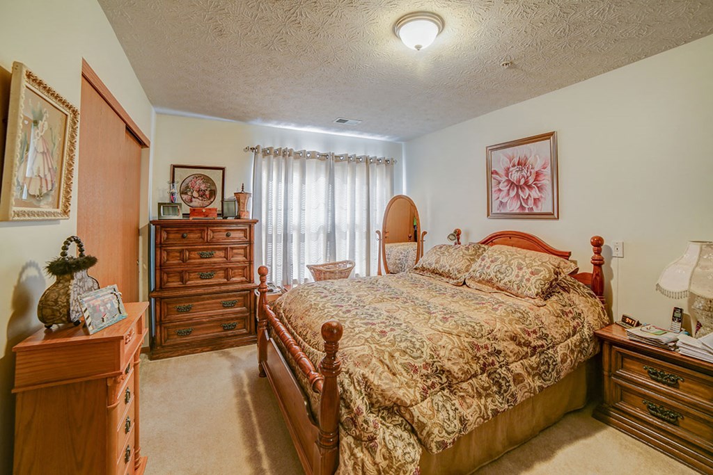 a bedroom with a bed and dressers in it