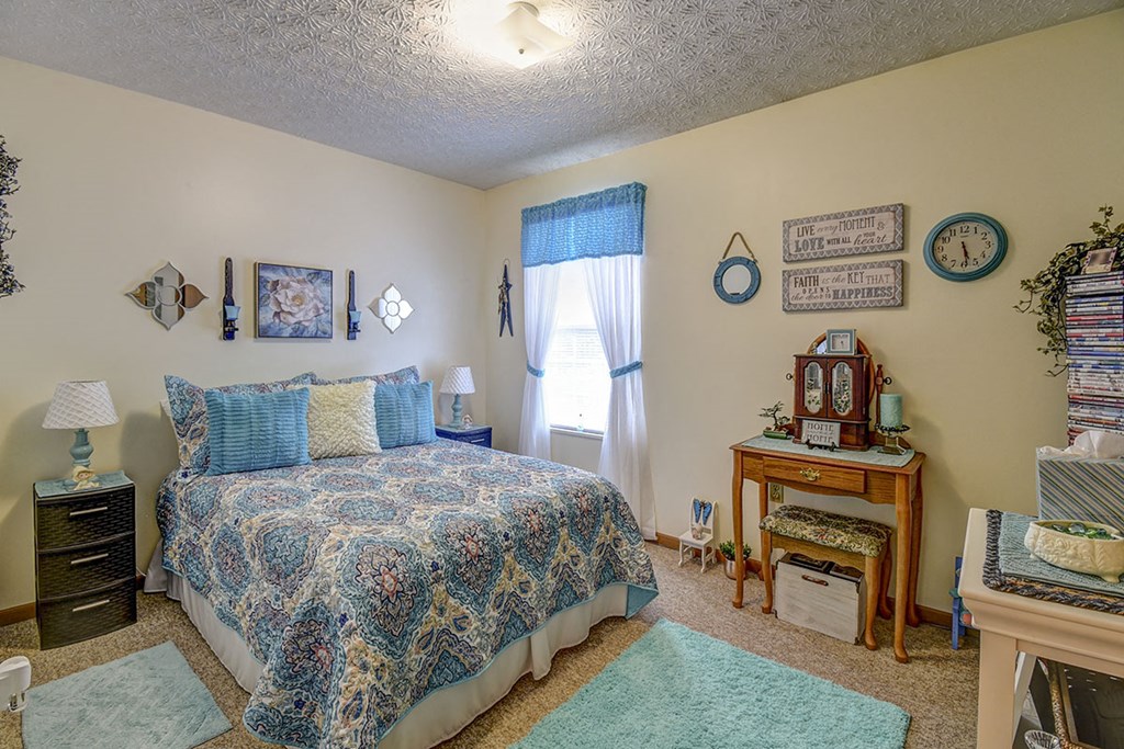 a bedroom with a bed and a dresser and a window