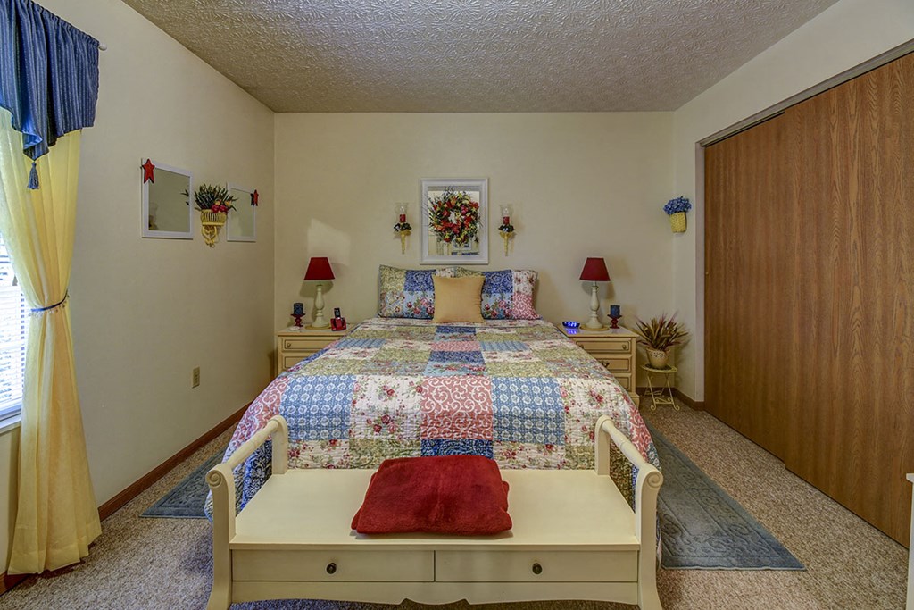 a bedroom with a bed with a quilt