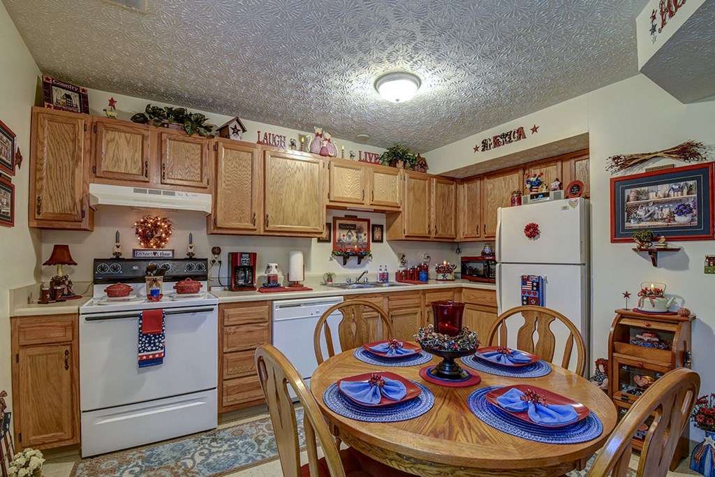a kitchen with white appliances and a dining table