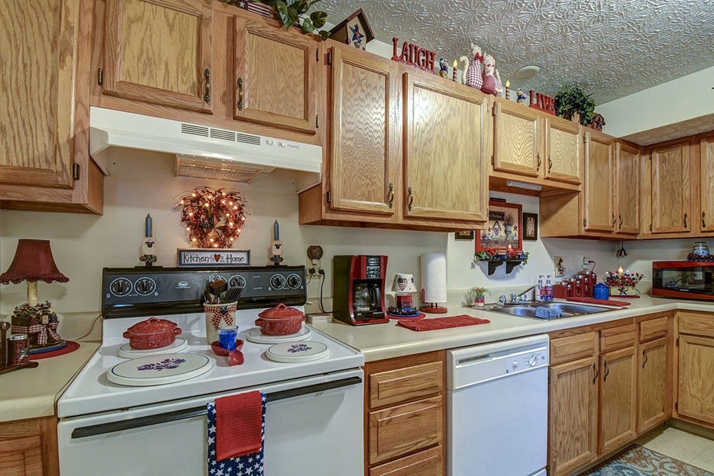a kitchen with white appliances and wooden cabinets
