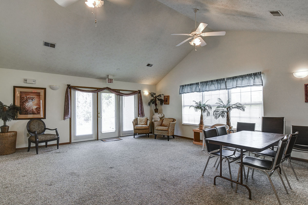 a living room with a dining room table and a ceiling fan