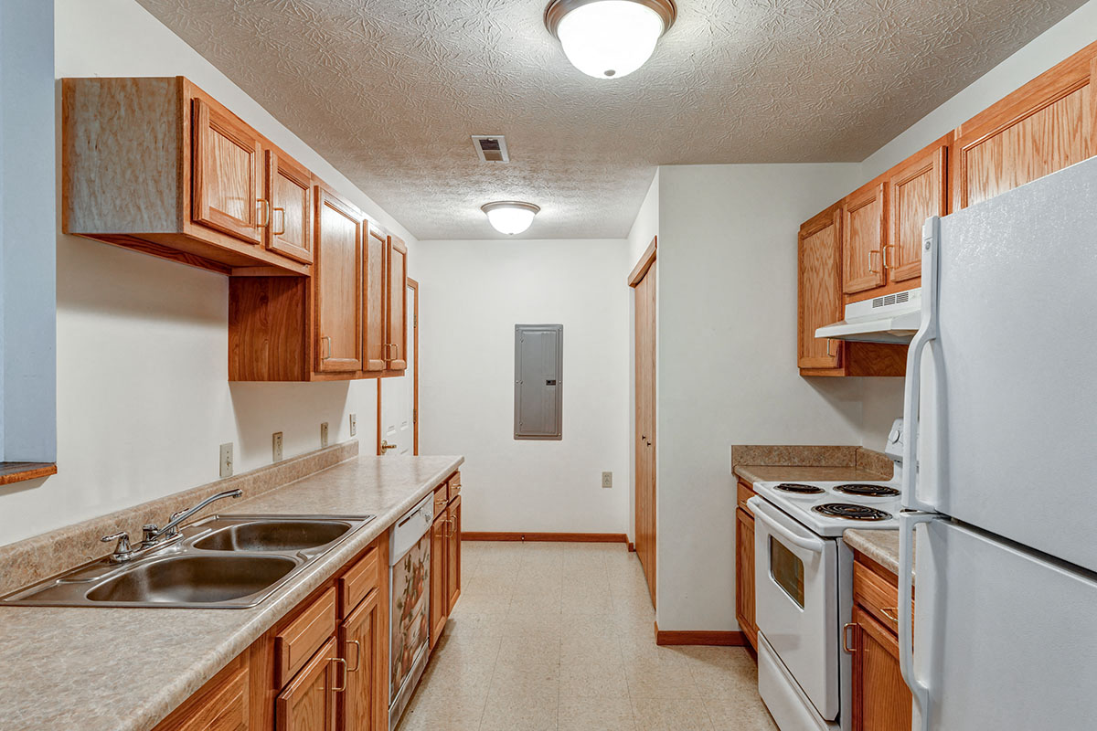 a kitchen with white appliances and wooden cabinets