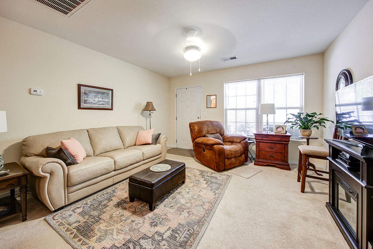 a living room with a couch and chair and a piano
