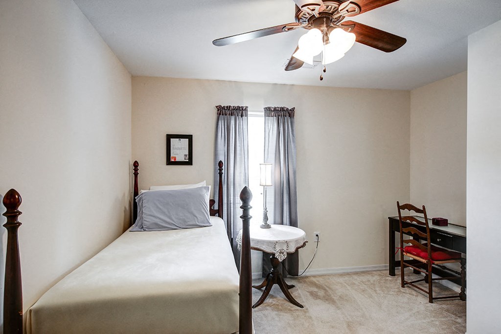 a bedroom with a bed and a ceiling fan