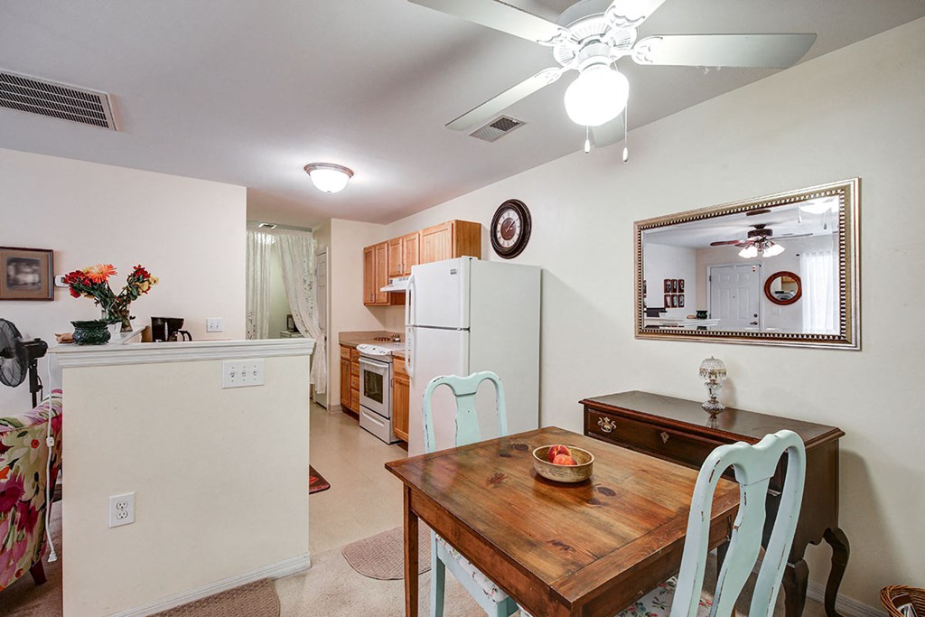 a kitchen with a dining table and a refrigerator