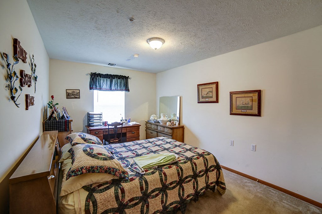a bedroom with a bed and a dresser and a window