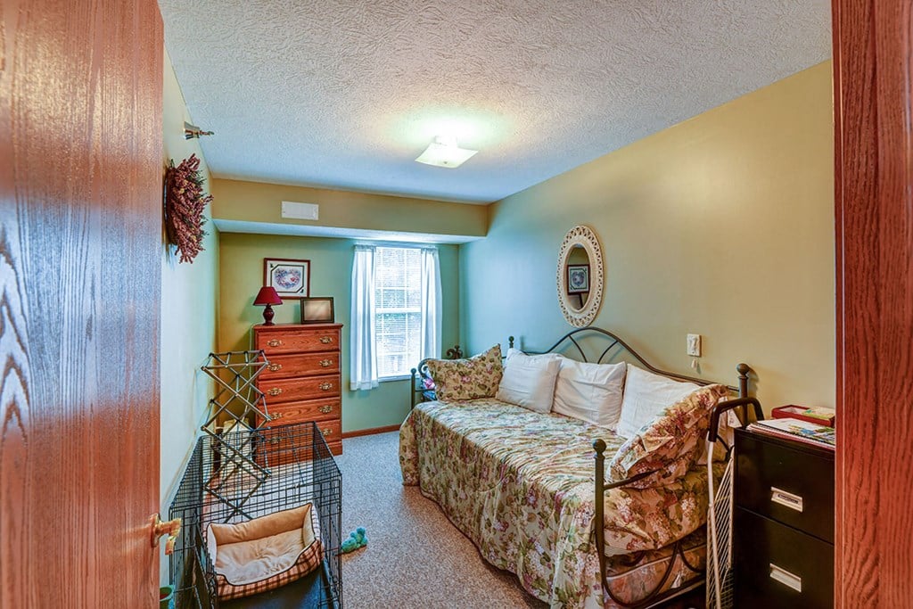 a bedroom with a bed and a crib and a dresser