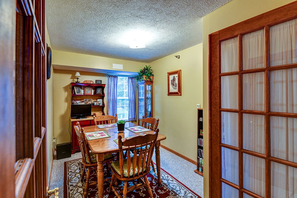 a dining room with a wooden table and chairs