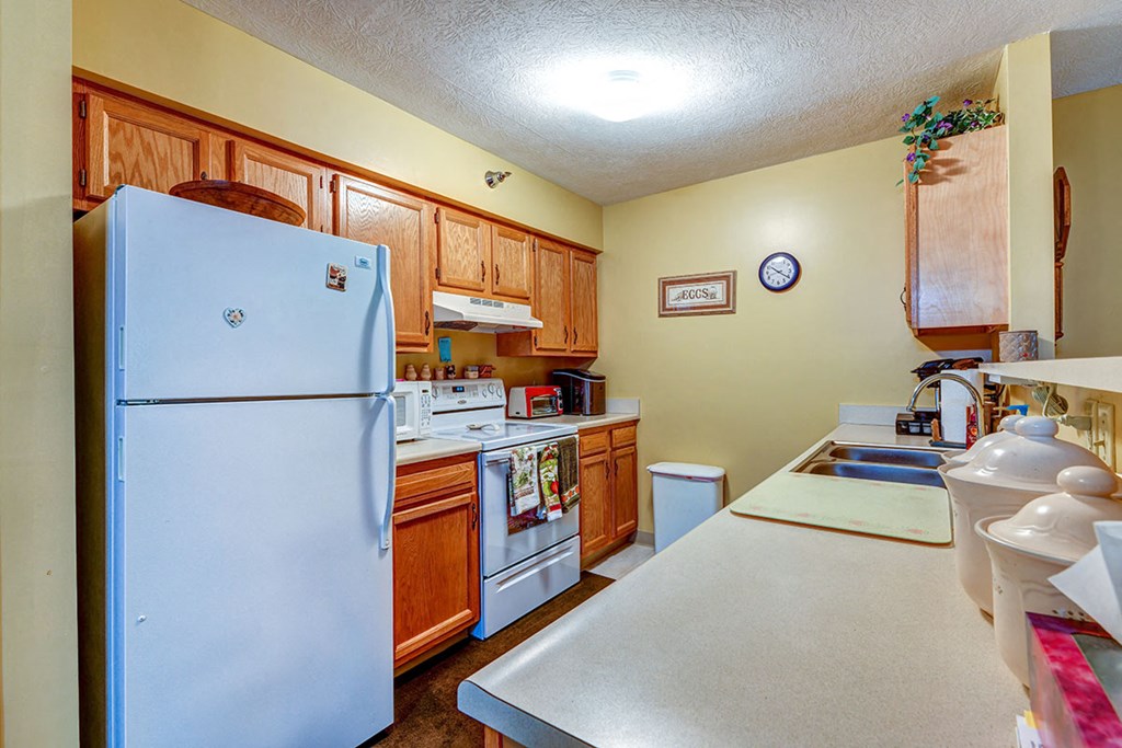 a kitchen with white appliances and wooden cabinets