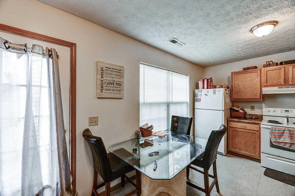 a kitchen with a dining table and a refrigerator