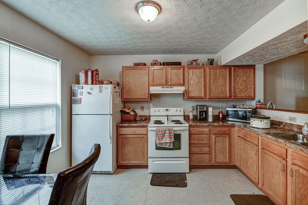 a kitchen with white appliances and wooden cabinets
