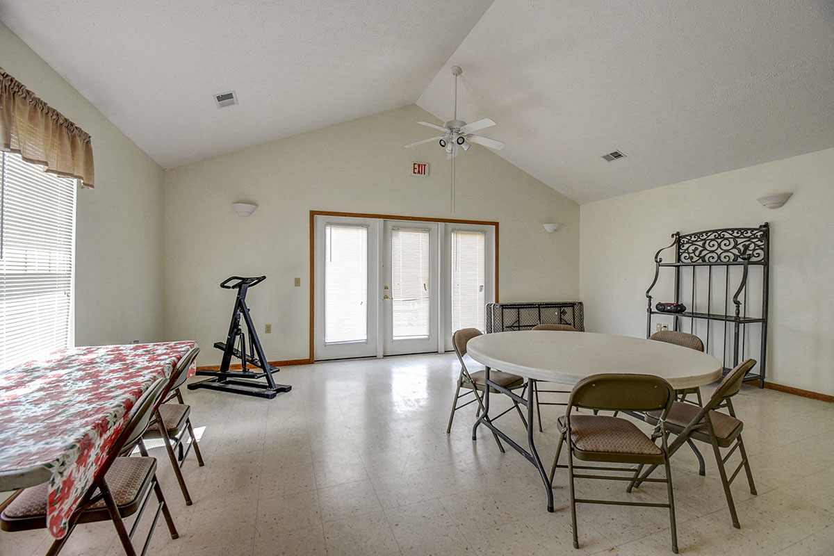 a dining room with a table and chairs and a fan