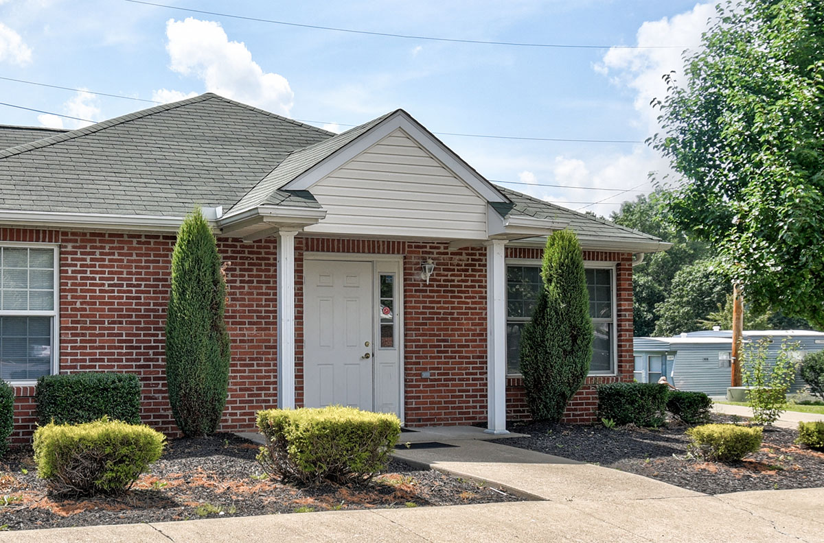 the front of a brick house with a white door