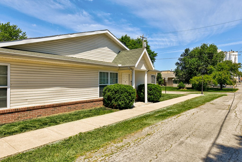 a white house with a sidewalk and a street