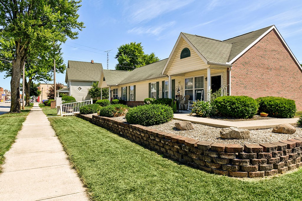 a brick house with a yard and a sidewalk