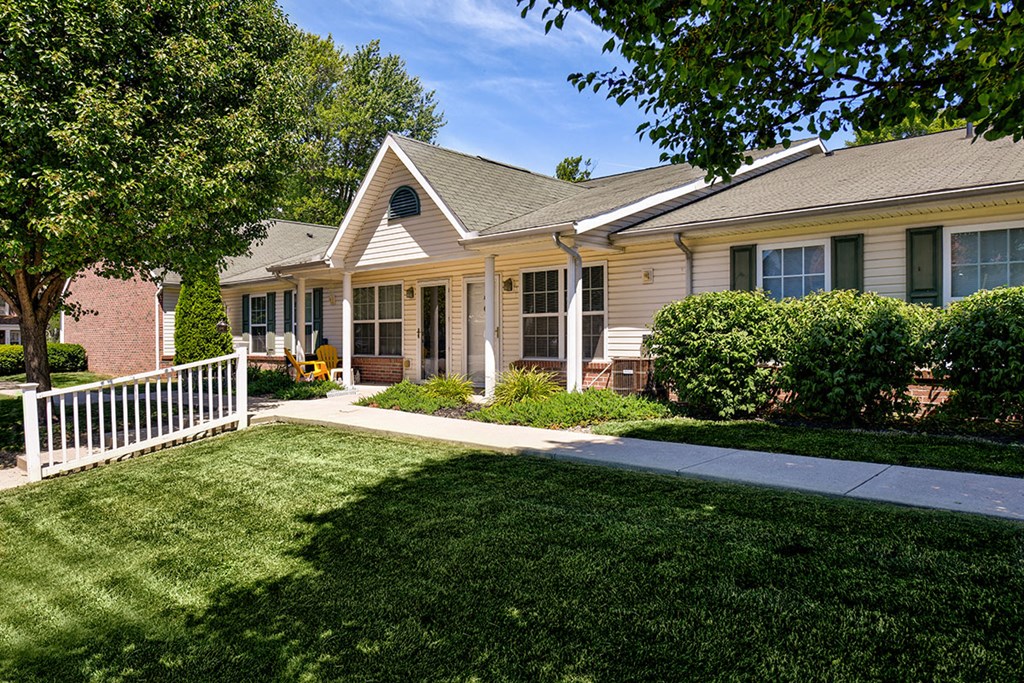a yard in front of a house with a white fence