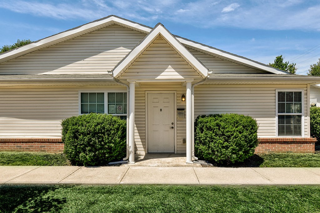 the front of a white house with a white door