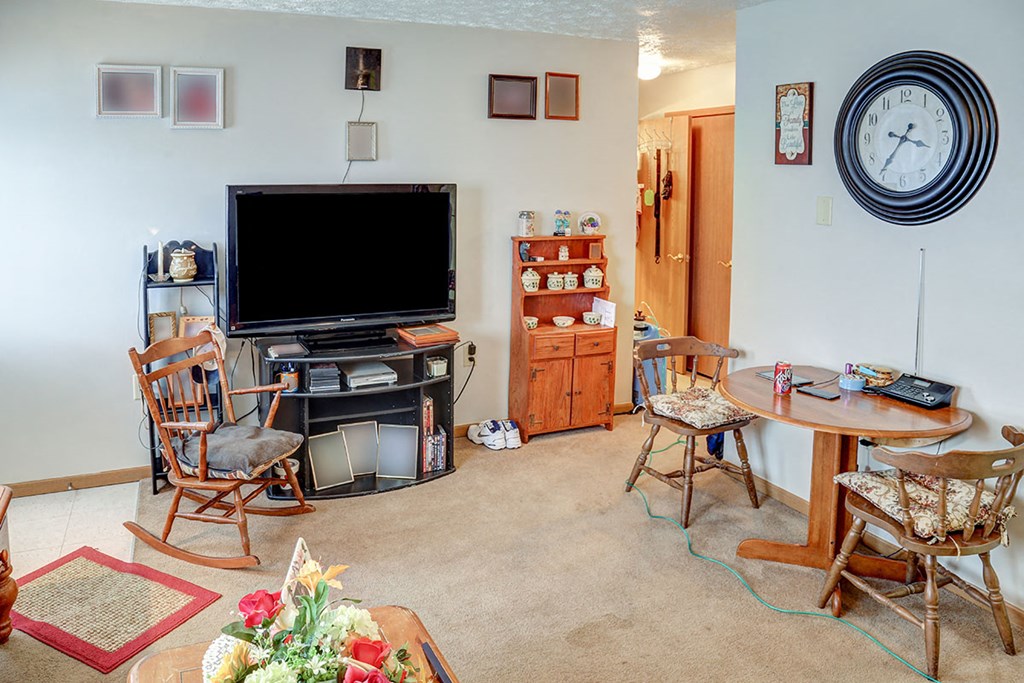a living room with a television and a table and chairs