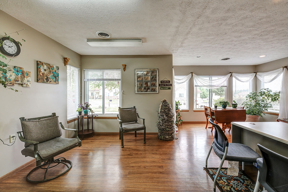 a living room with chairs and a bar and a piano