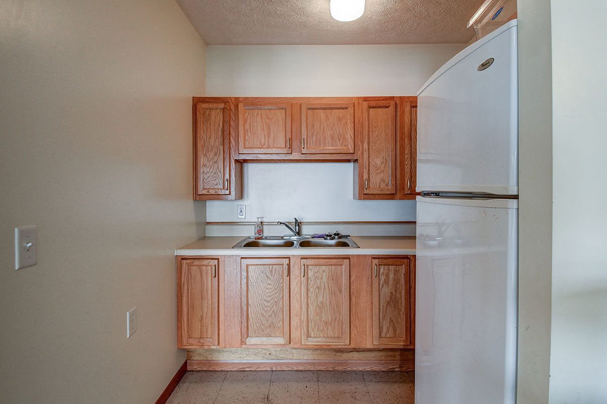 a kitchen with wooden cabinets and a white refrigerator
