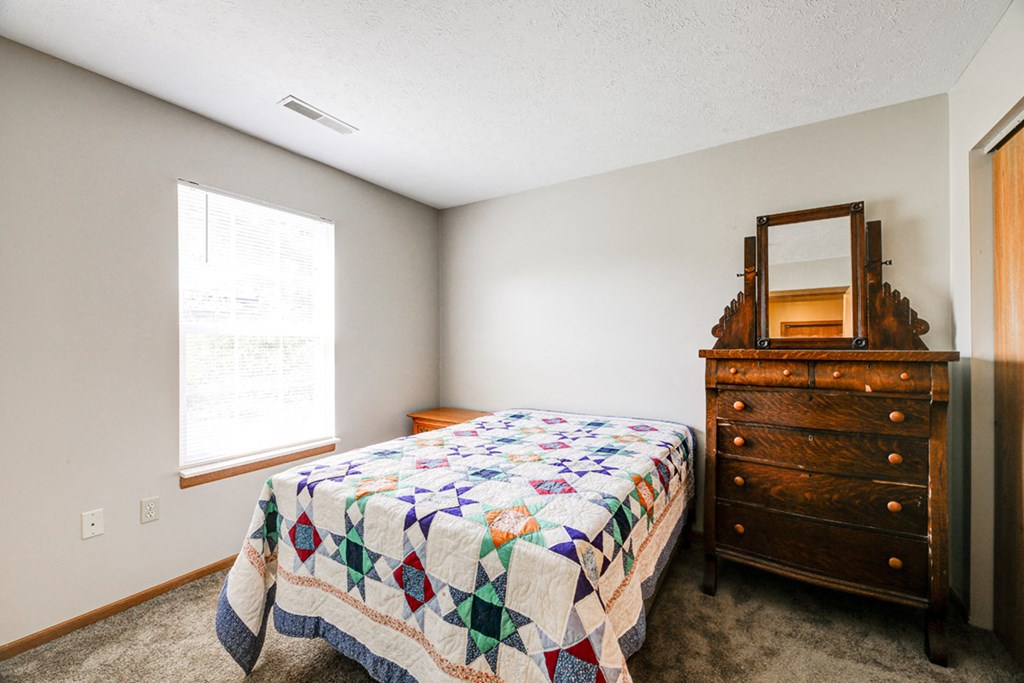 a bedroom with a bed and a dresser