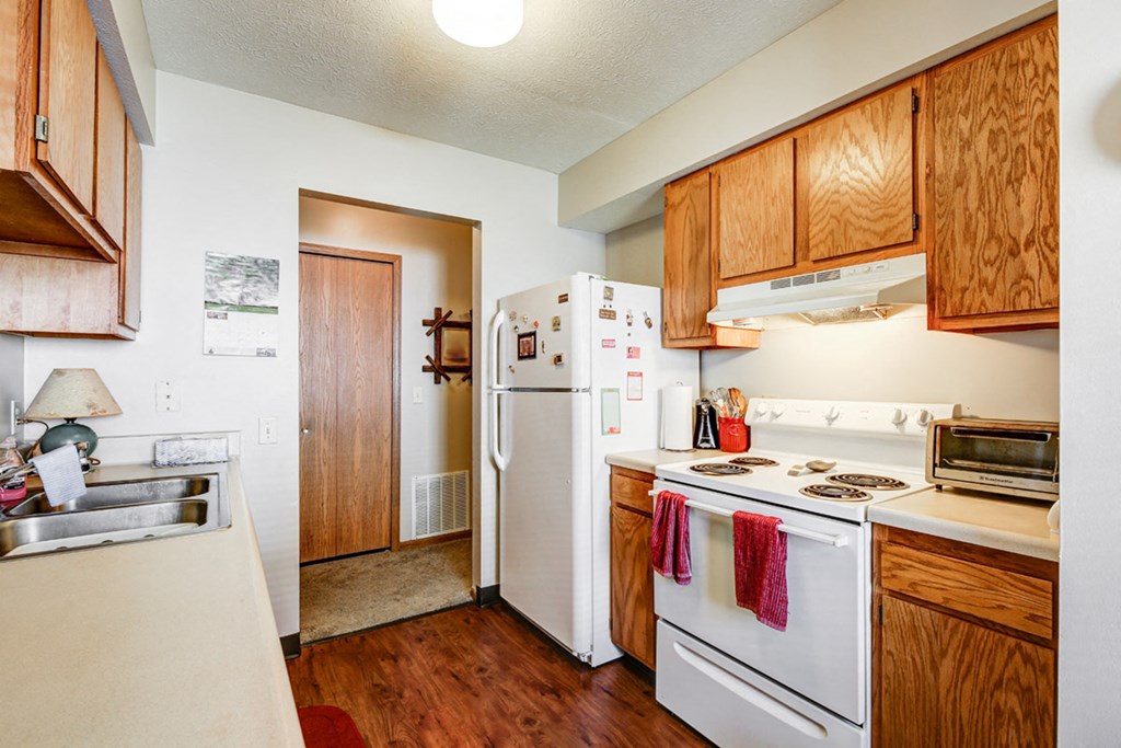 a kitchen with white appliances and wooden cabinets