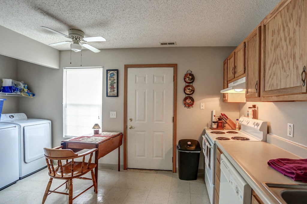 a kitchen with a counter top and a door to a laundry room