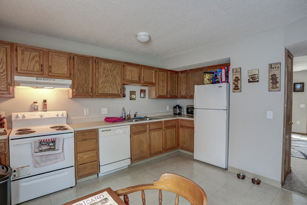 a kitchen with white appliances and wooden cabinets