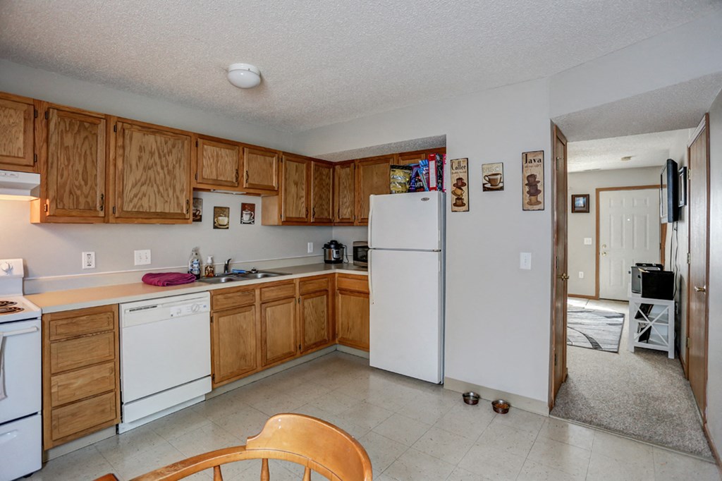 a kitchen with white appliances and wooden cabinets