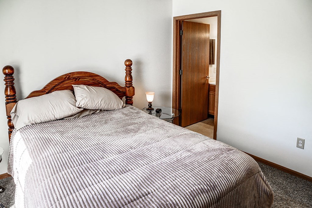 a bedroom with a bed and a door to a bathroom