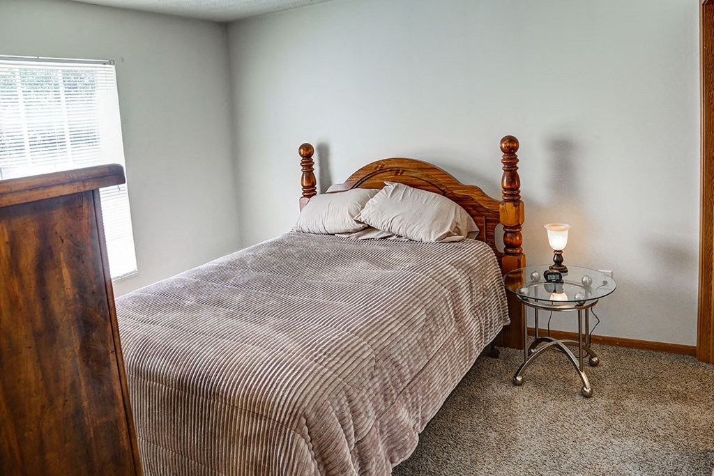 a bedroom with a bed and a night stand