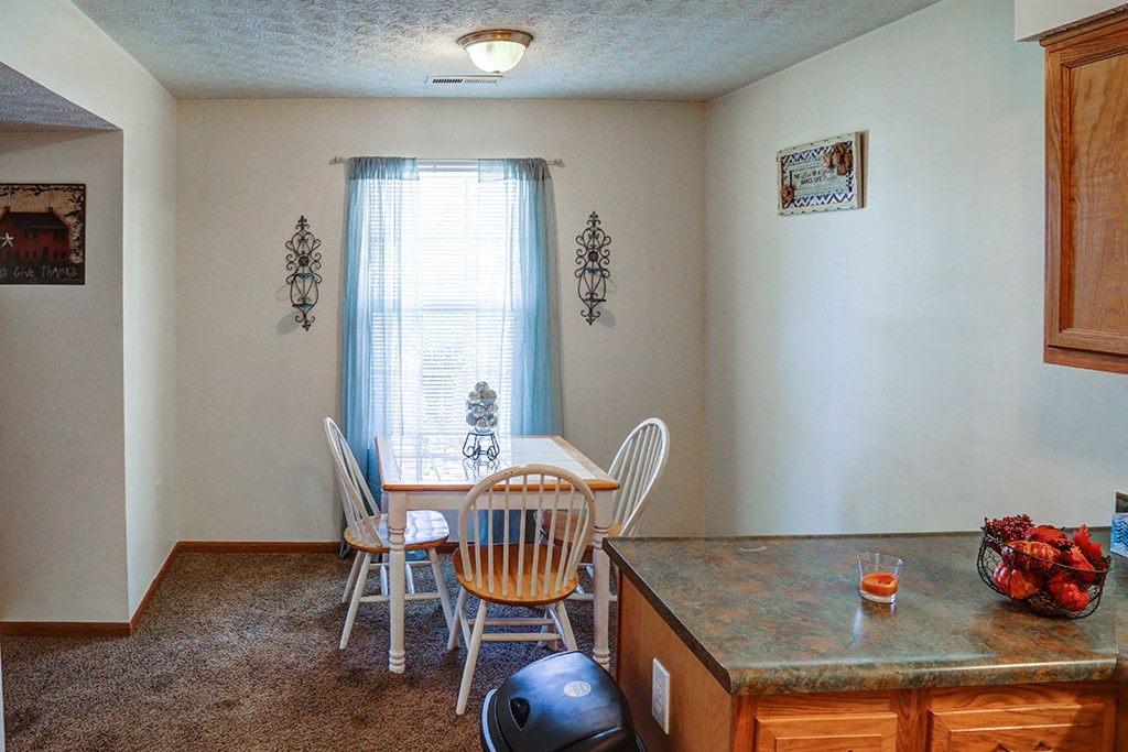 a dining room with a table and chairs and a counter