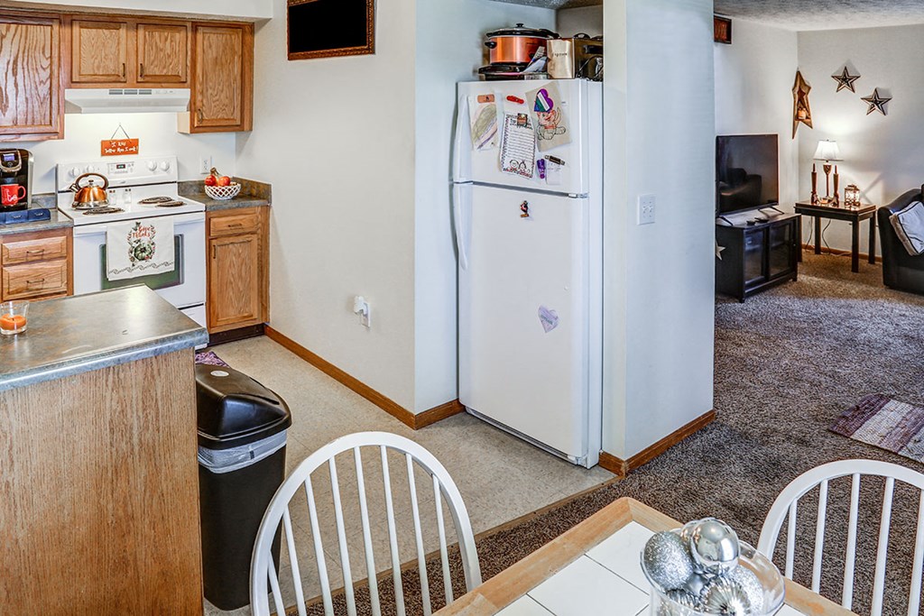 a kitchen with a refrigerator and a table and chairs