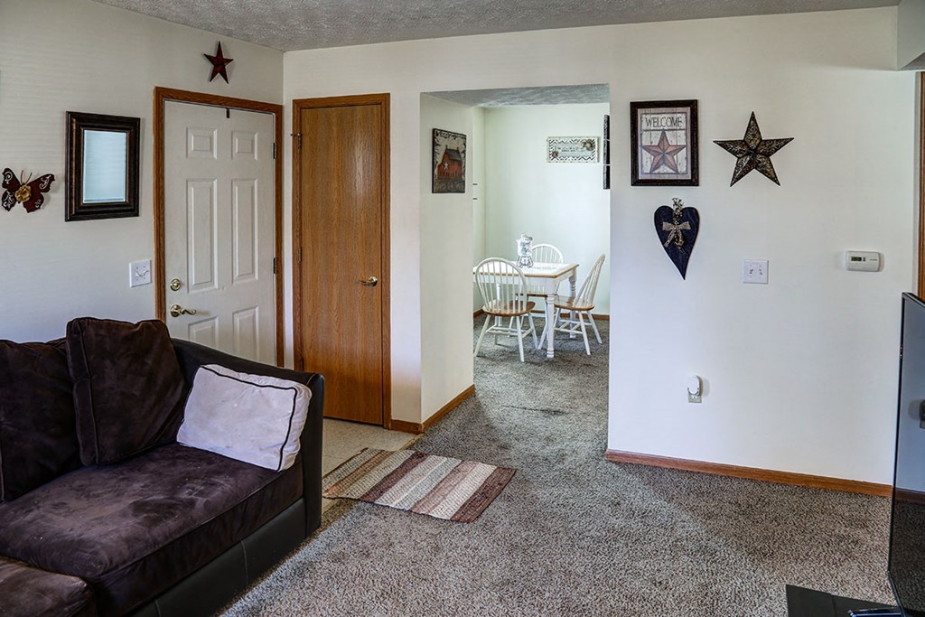 a living room with a couch and a door to a dining room