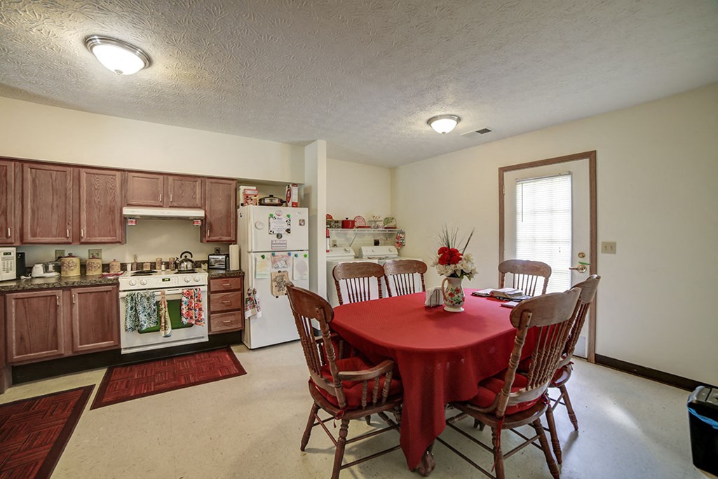 a kitchen with a red table and chairs