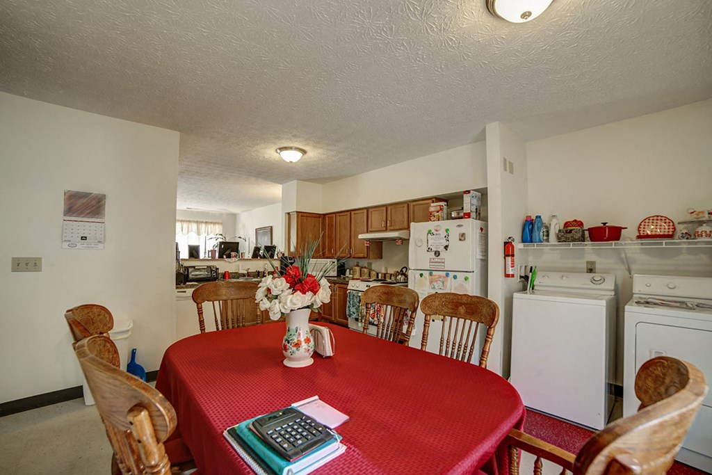 a kitchen with a table with a red tablecloth