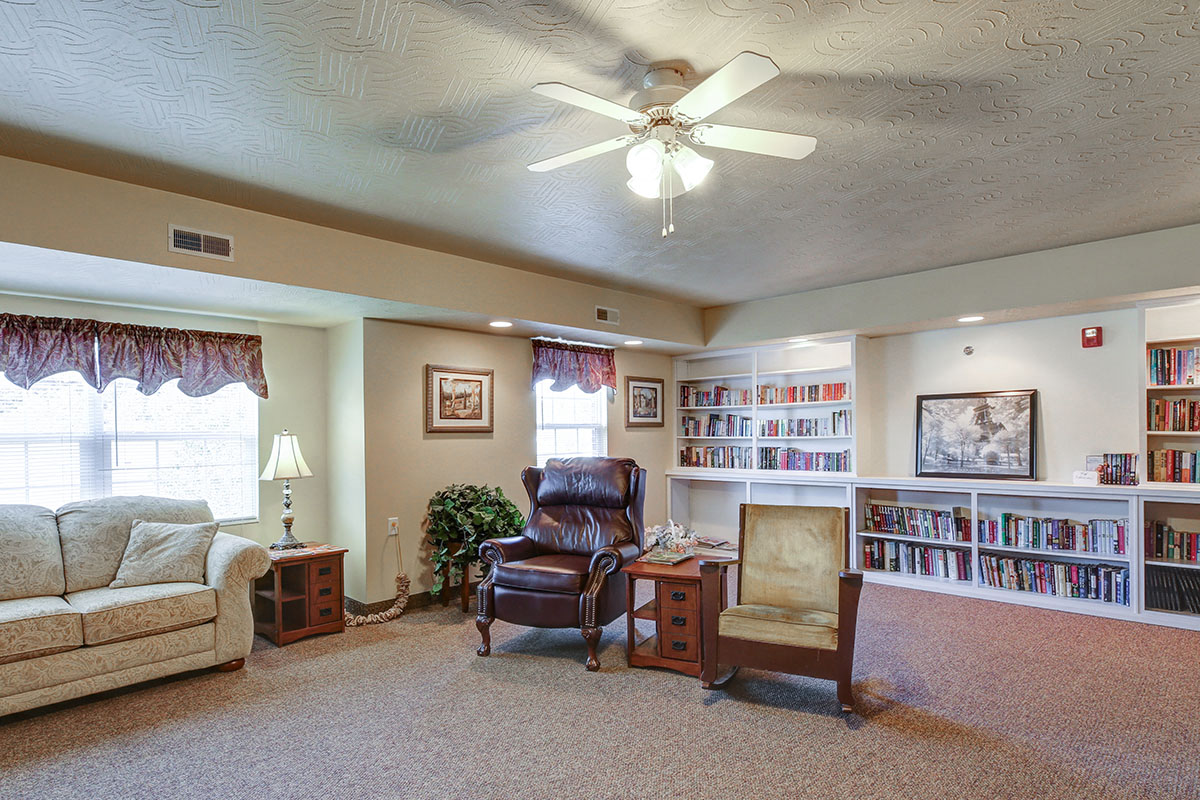 a living room filled with furniture and a ceiling fan