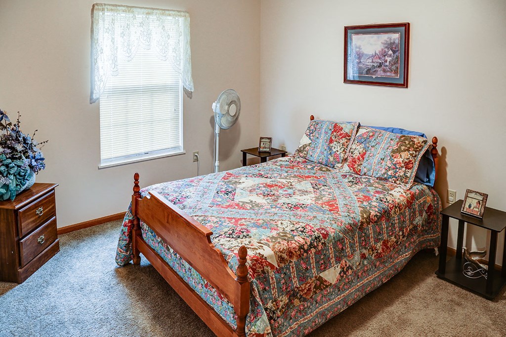 a bedroom with a bed and a fan