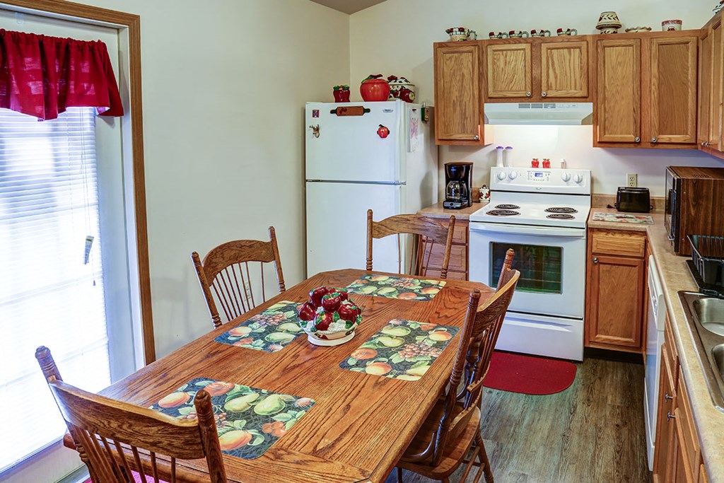 a kitchen with a wooden table and a white refrigerator