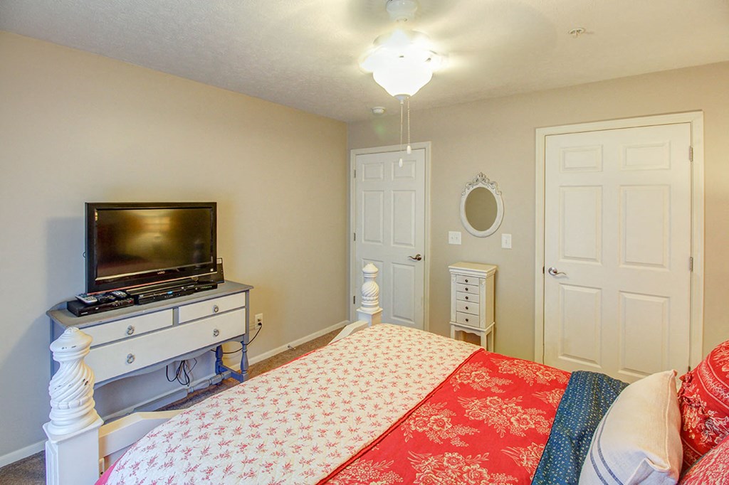 a bedroom with a bed and a television