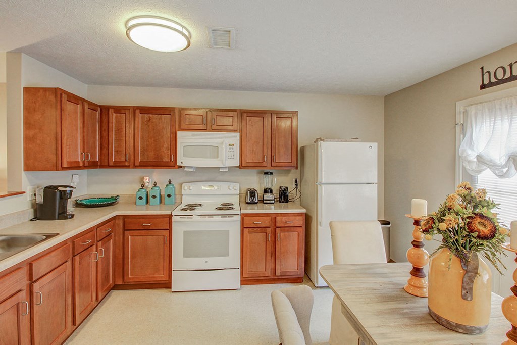 a kitchen with white appliances and wooden cabinets