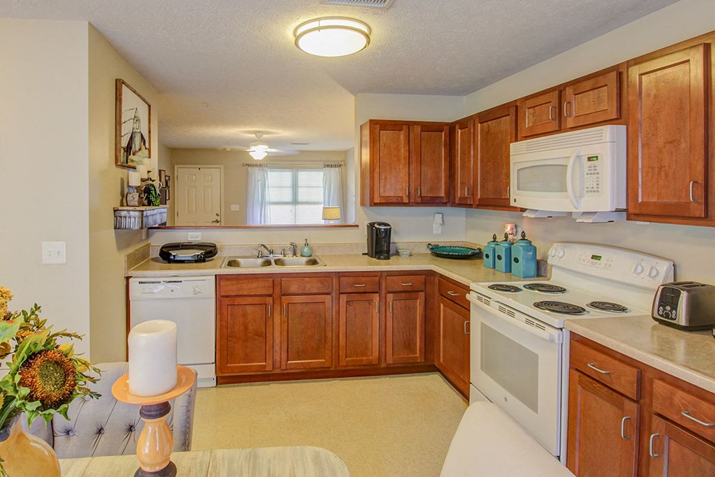a kitchen with white appliances and wooden cabinets