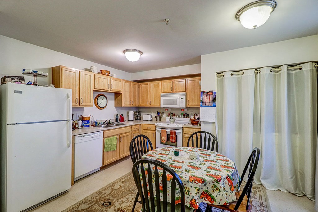 a kitchen with wooden cabinets and a table and chairs
