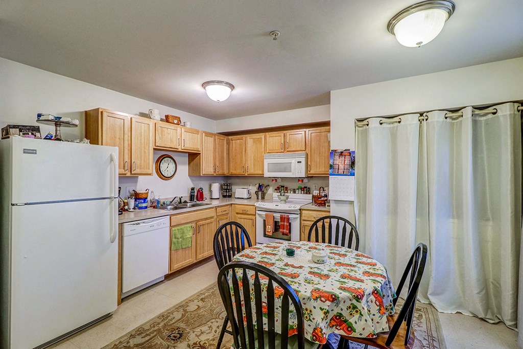 a kitchen with wooden cabinets and a table and chairs