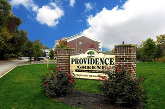 the sign for providence greene is in front of a brick building