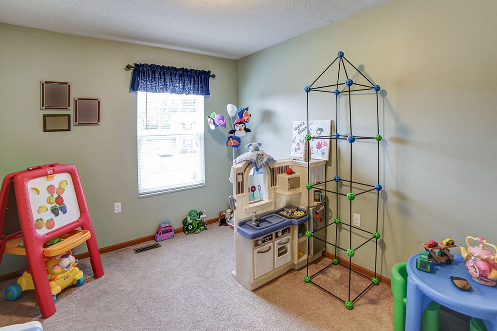 a play room with toys and a play kitchen