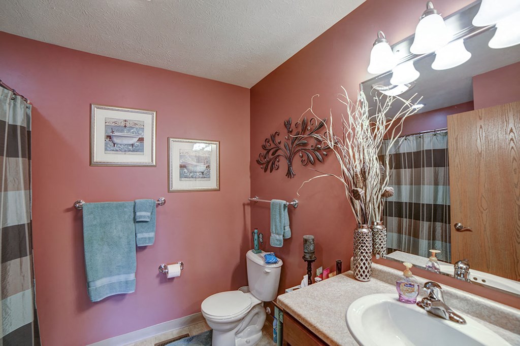 a bathroom with pink walls and a sink and a toilet