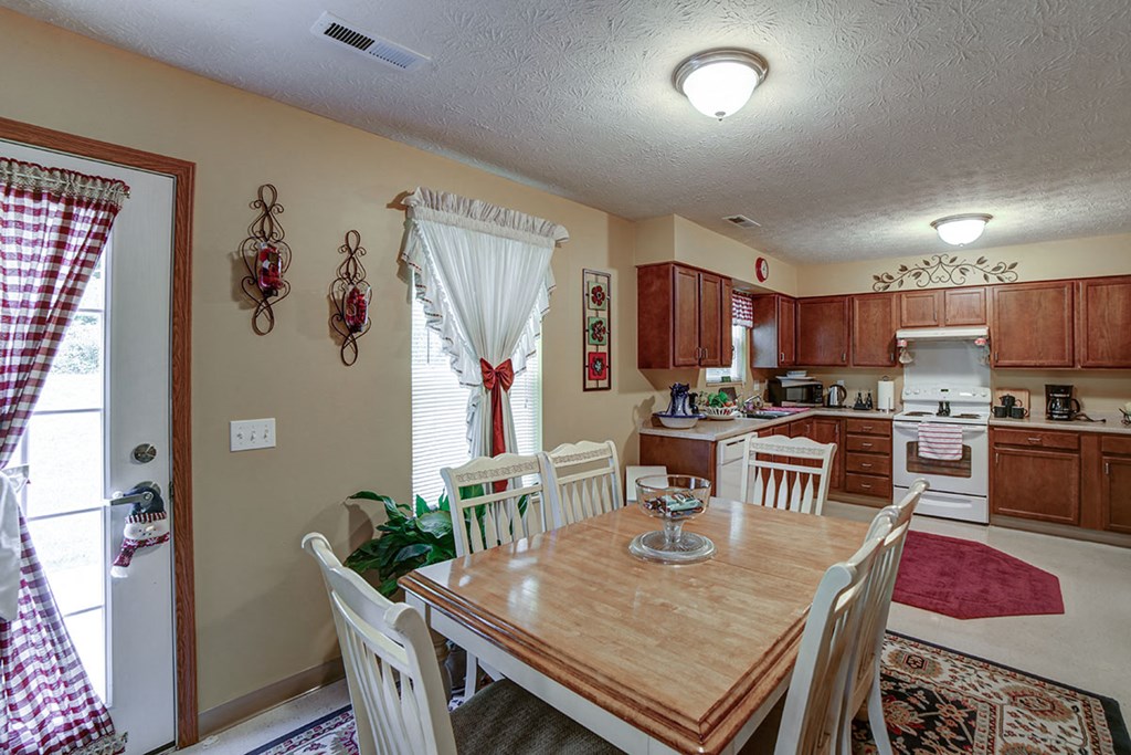 a dining room table with a kitchen in the background