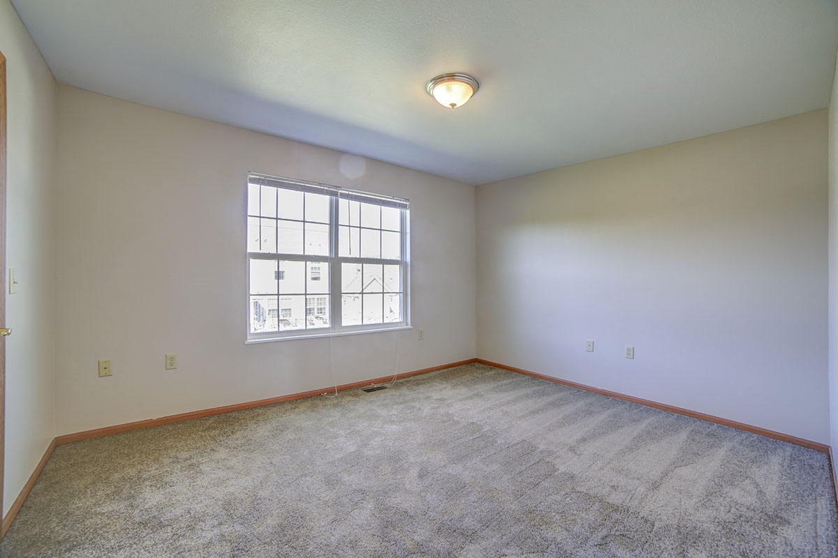 a living room with carpet and a large window
